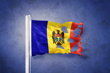 Torn flag of Moldova flying against grunge background