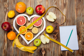 Fruit Diet, centimeter and plan on a wooden background