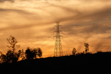high voltage pole on the top of mountain with golden sky