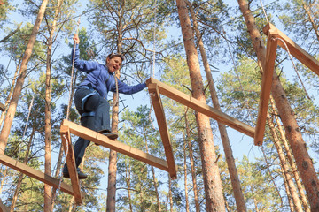Obraz na płótnie Canvas Gomel, Belarus - OCTOBER 5, 2014: Rope town for a family holiday in the countryside. Family competition to overcome aerial obstacles.
