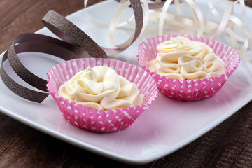 Whipped cream swirl colorful pink on wooden table
