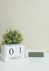 White wooden calendar with black 1 february word with clock and