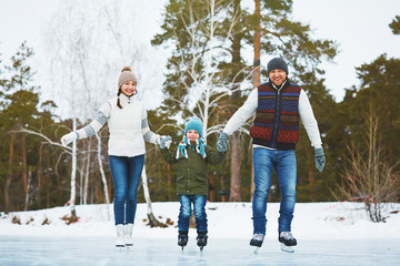 Fototapeta na wymiar Family on ice-rink