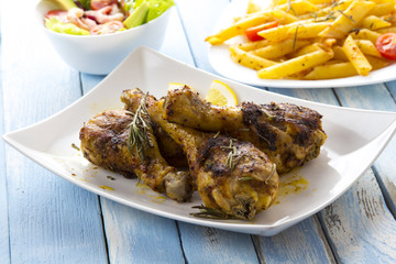 Grilled chicken legs fried tomatoes vegetables fresh salad avocado spices food in the kitchen
