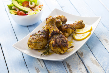 Grilled chicken legs fried tomatoes vegetables fresh salad avocado spices food in the kitchen
