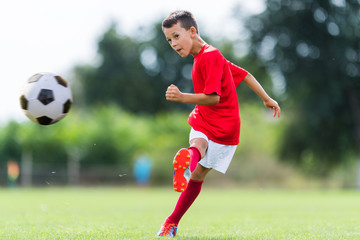 Obraz na płótnie Canvas Boy kicking soccer ball