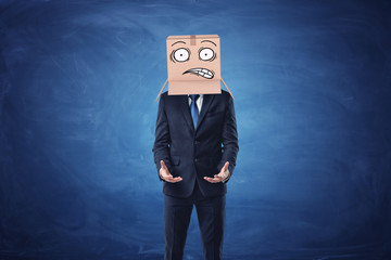 Businessman is wearing cardboard box with drawn shocked face on his head