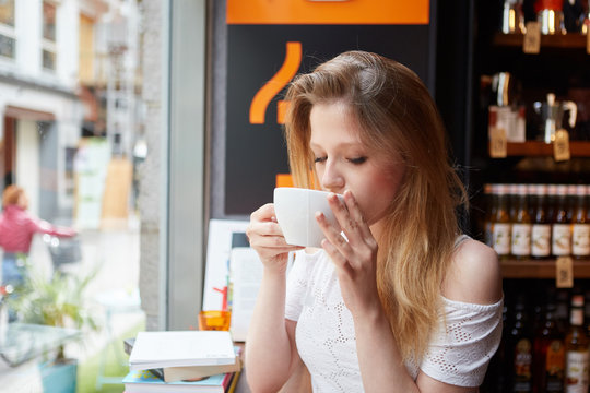 A shot of a beautiful woman drinking coffee in a cafe