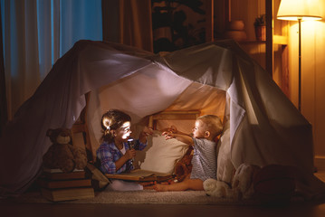 children boy and girl playing and frighten each other in  tent