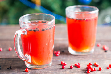 Two Cups of Red Hot Tea Drink with Cranberries and Cinnamon on a Wooden Background, Winter Hot Drinks Concept
