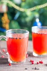 Hot Spicy Christmas Drink of Cranberry and Spice with Christmas Background, Vertical View