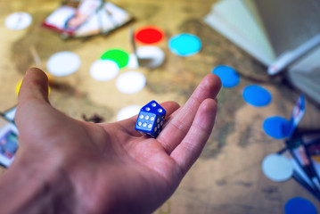 hand throws the dice on background world map Board games