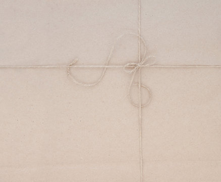 Cardboard packaging, tied with jute thread.