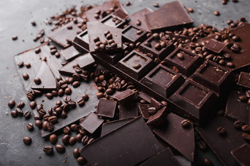 Broken slices of chocolate and coffee beans. Chocolate chocolate chunks. Chocolate bar pieces. A large bar of chocolate . Background with chocolate