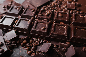 Broken slices of chocolate and coffee beans. Chocolate chocolate chunks. Chocolate bar pieces. A large bar of chocolate . Background with chocolate