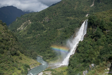 misty waterfall with rainbow in the himalayas © is