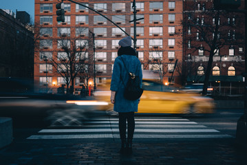 Woman with backpack waiting for green traffic light