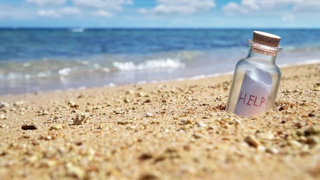 Help request in a bottle on the beach. Slow motion.