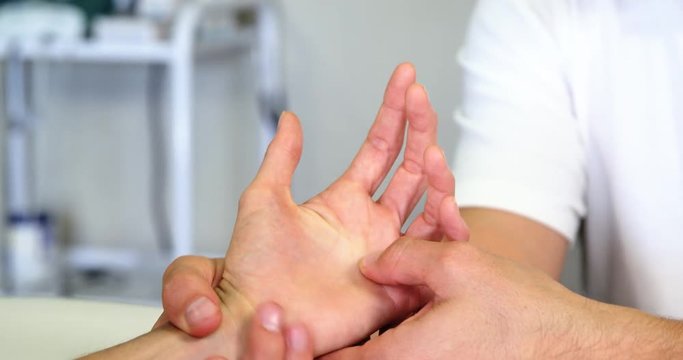 Physiotherapist giving hand massage to a woman in clinic 4k