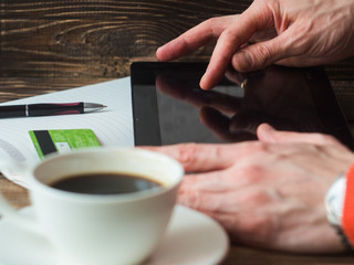 Man shopping online using laptop, drinking coffe. close-up side view