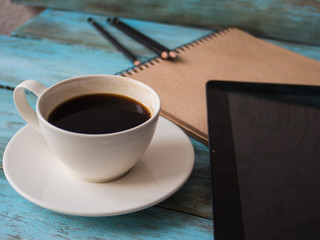 top view of coffee ,notepad with pen on wooden table, side view. Workplace