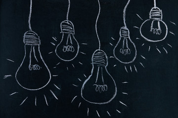 Idea concept, Many Light bulb lamps drawn on blackboard background with copy space
