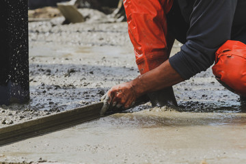 Workers make smooth of concrete surface .