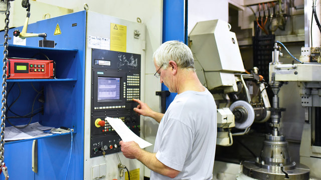 Arbeiter bedient eine CNC Fr&auml;smaschine im Maschinenbau // Worker serves a CNC milling machine in mechanical engineering