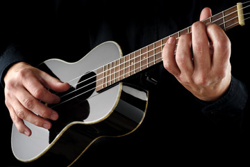 Obraz na płótnie Canvas playing black ukulele