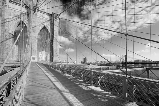 Fototapeta Empty Brooklyn Bridge footpath in a sunny day, New York in black and white