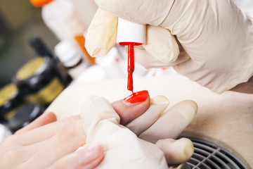 Manicure specialist care by finger nail in beauty salon.