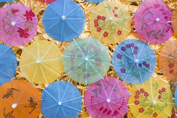 Fototapeta na wymiar Summer concept background, colorful paper umbrella on gold paper background, outdoor day light