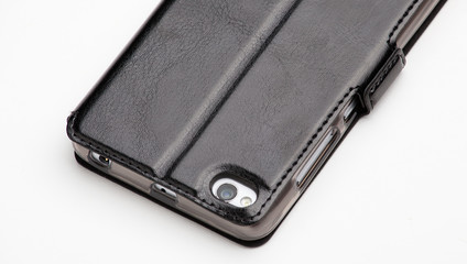 Naklejka premium Smartphone in black leather cover, back view isolated on white background