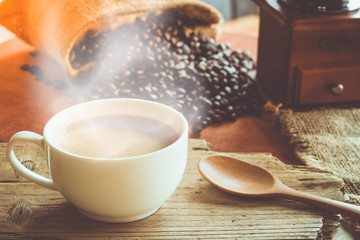 A cup of black coffee in white cup with coffee bean in sack bag