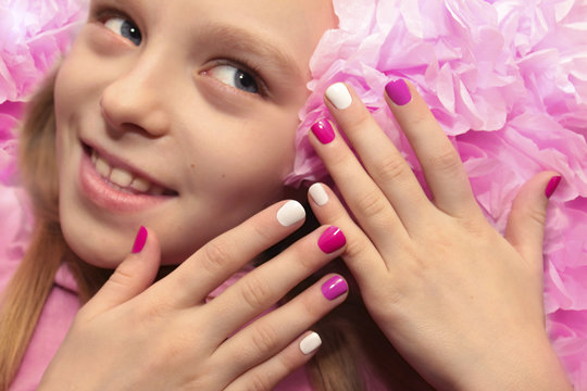 Pink white children's manicure for the girl with the flower.
