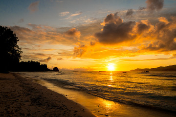 Amazing gold sunset with huge clouds in a tropical island, Anse Severe, La Digue, Seychelles