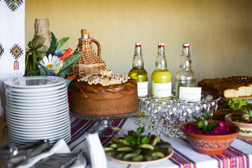 Pickled vegetables and salads served in clay dishes stand on emb