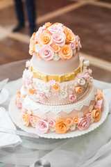 Obraz na płótnie Canvas Delicious wedding cake decorated with orange and pink roses stan