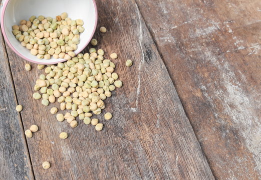 dry green peas, sugar pea in bowl on the wood board background.