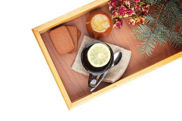 Tea with lemon on a tray and honey biscuits on a white backgroun