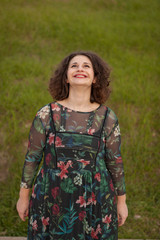 Happy curvy girl with curly hair in the landscape