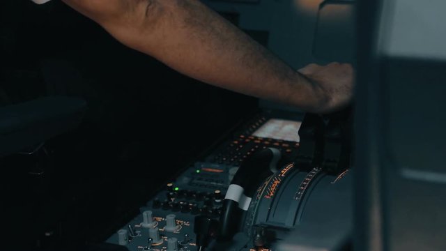 Close shot of cabin interior of Airbus A319 A320 A321. Flight deck and pedestal. Aircraft commander in white shirt use thrust and thrust reverse control levers