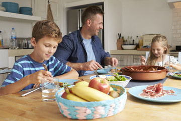 Father And Children At Home In Eating Meal Together