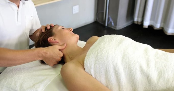 Physiotherapist giving neck massage to a woman in clinic 4k