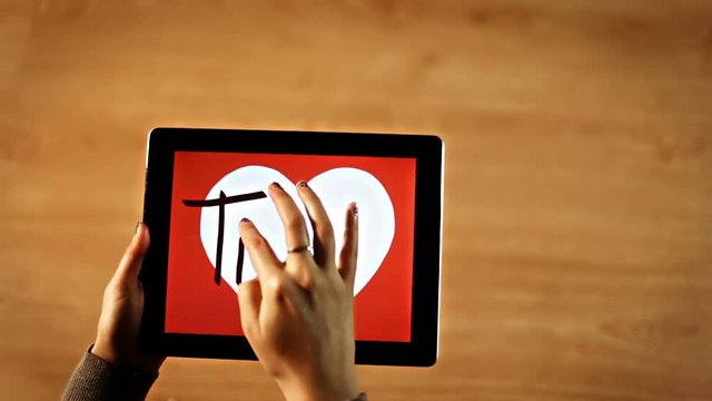 Ti amo calligraphy. Female writing inside white heart on tablet hd