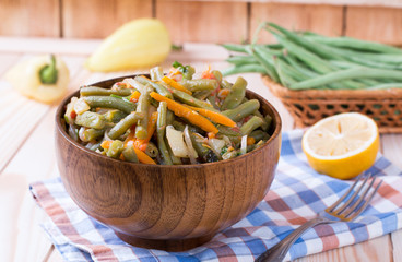 Braised green beans in a wooden bowl on the table