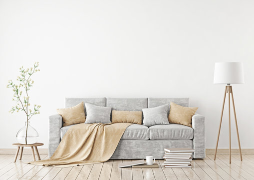 Empty white wall mockup with sofa, pillows, plaid and lamp on the floor. 3D rendering.