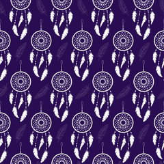 Seamless background of white feathers and dream catchers on a colored background. Pattern.