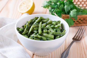 Cooked green beans with garlic and parsley in a white plate