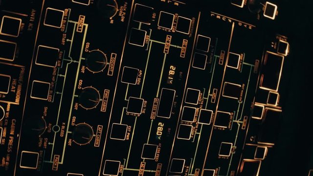 Rotating close shot of powered on overhead panel of modern aircraft with buttons and knobs. Interior of Airbus A319 A320 A321
